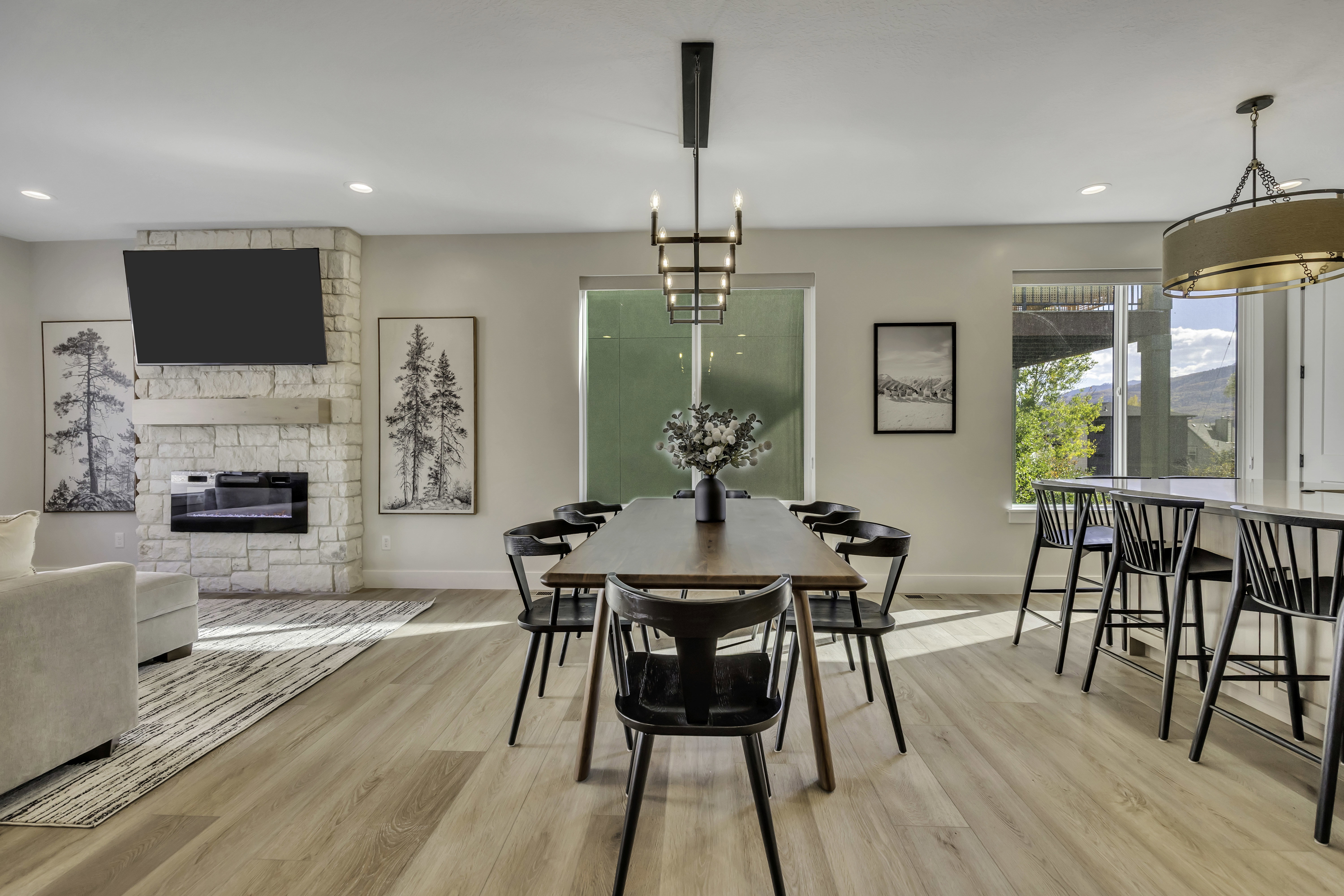 Dining room with a fireplace, light wood-style flooring, and hanging lights