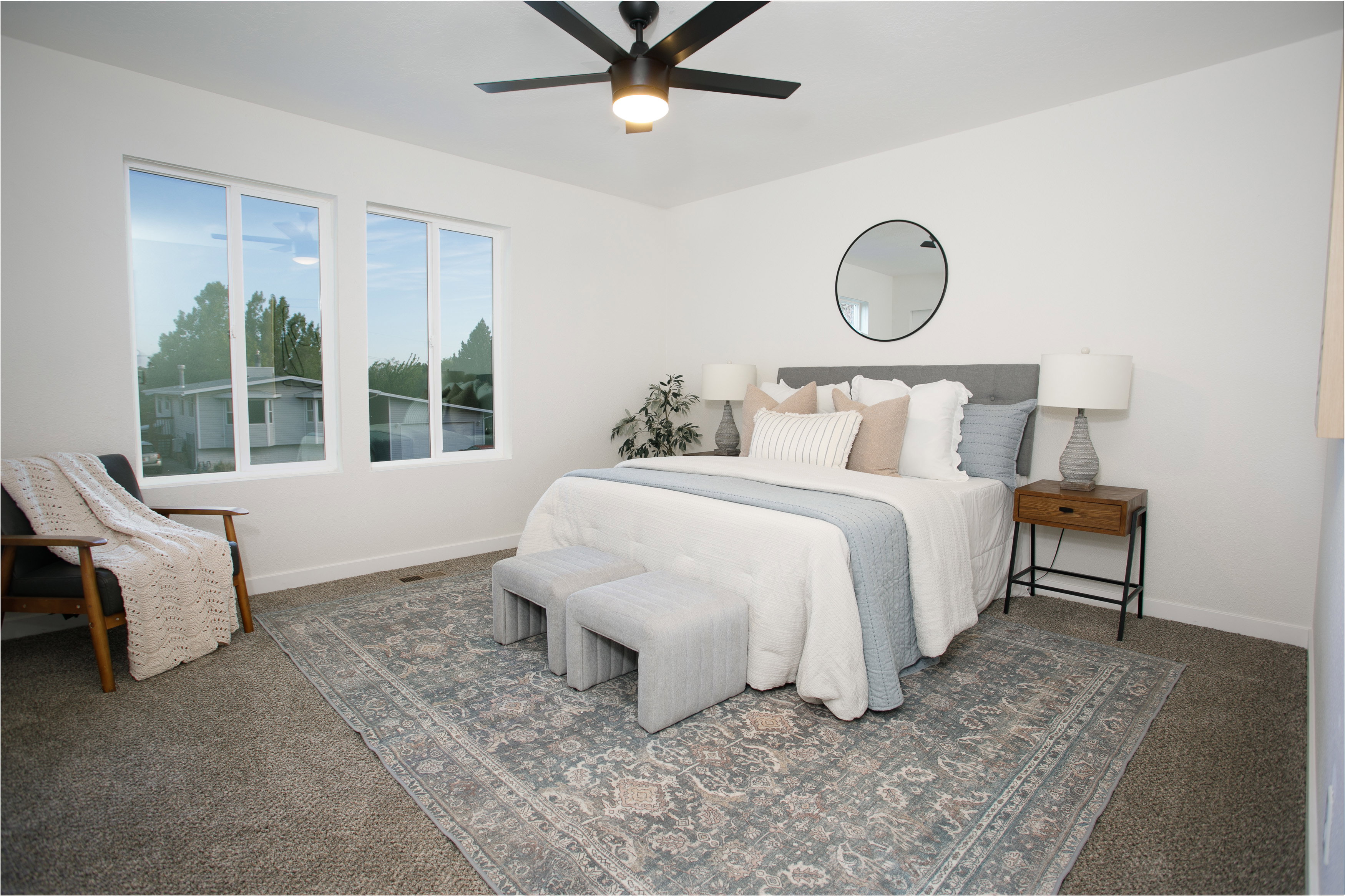 Spacious room featuring white walls, a contemporary ceiling fan, and large windows