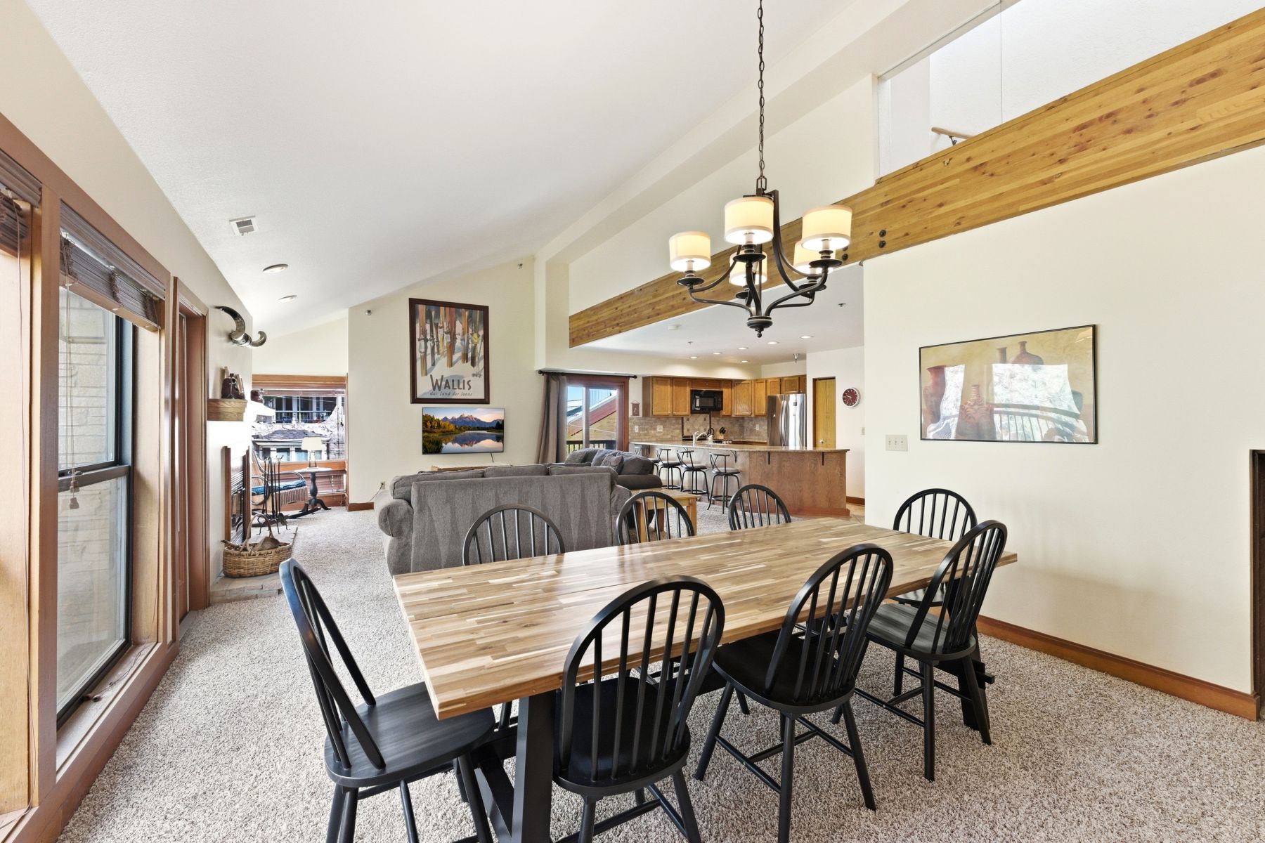 Open-concept dining area featuring vaulted ceilings, a decorative chandelier, and wood-finish flooring