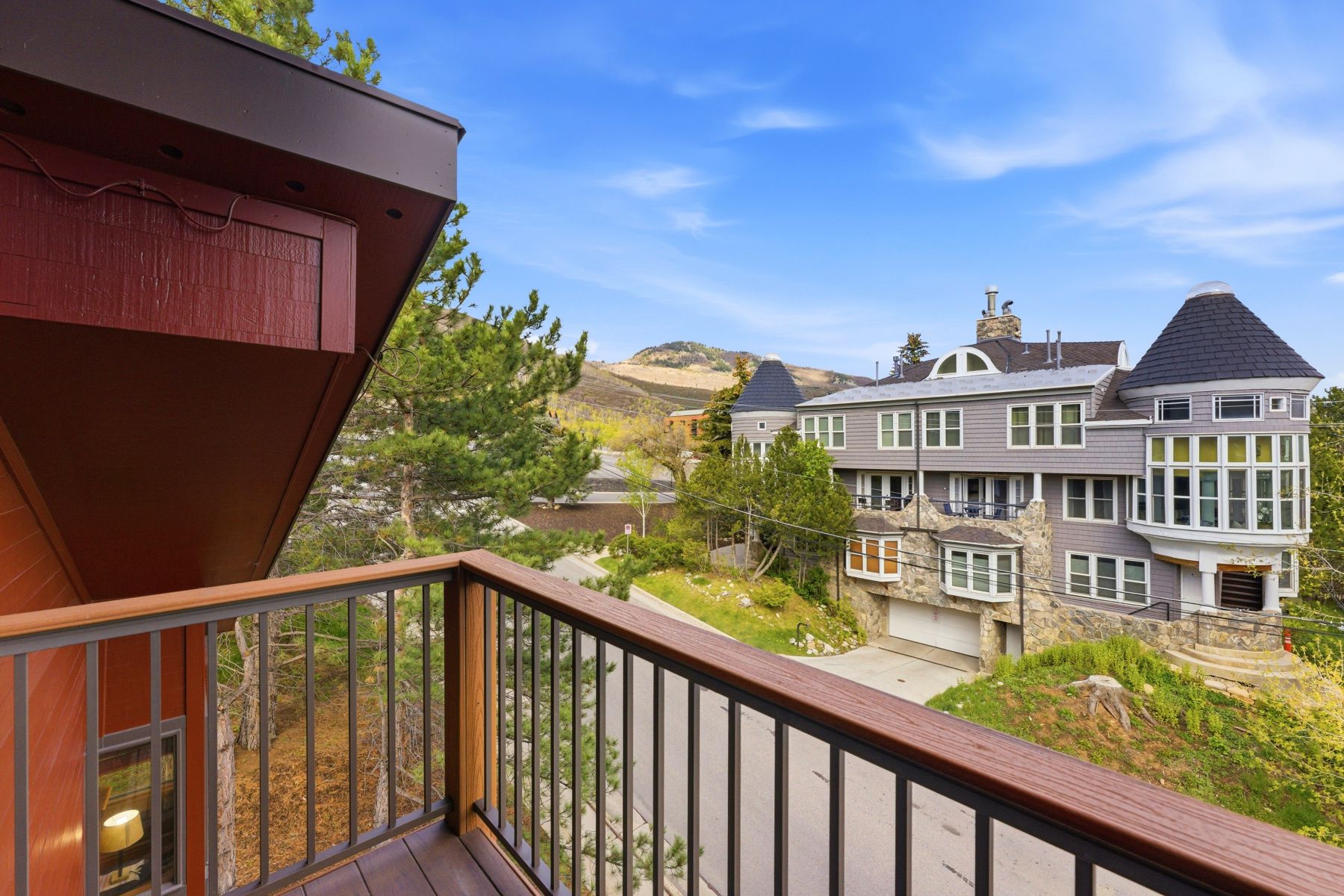 Upper-level balcony featuring composite decking and a metal railing with a wood-finish top rail