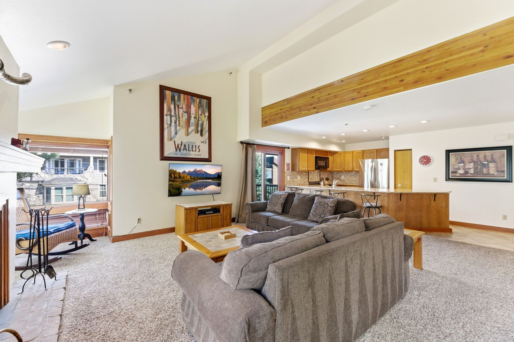 Vaulted ceilings featuring a prominent exposed wood beam