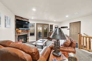 Living area with a stone-clad fireplace featuring a log mantel