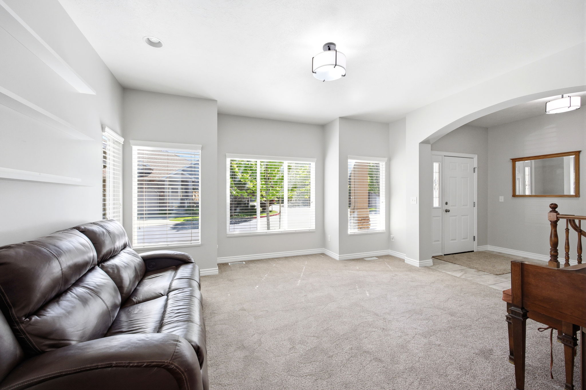 Bright living area with neutral carpeting and light gray walls