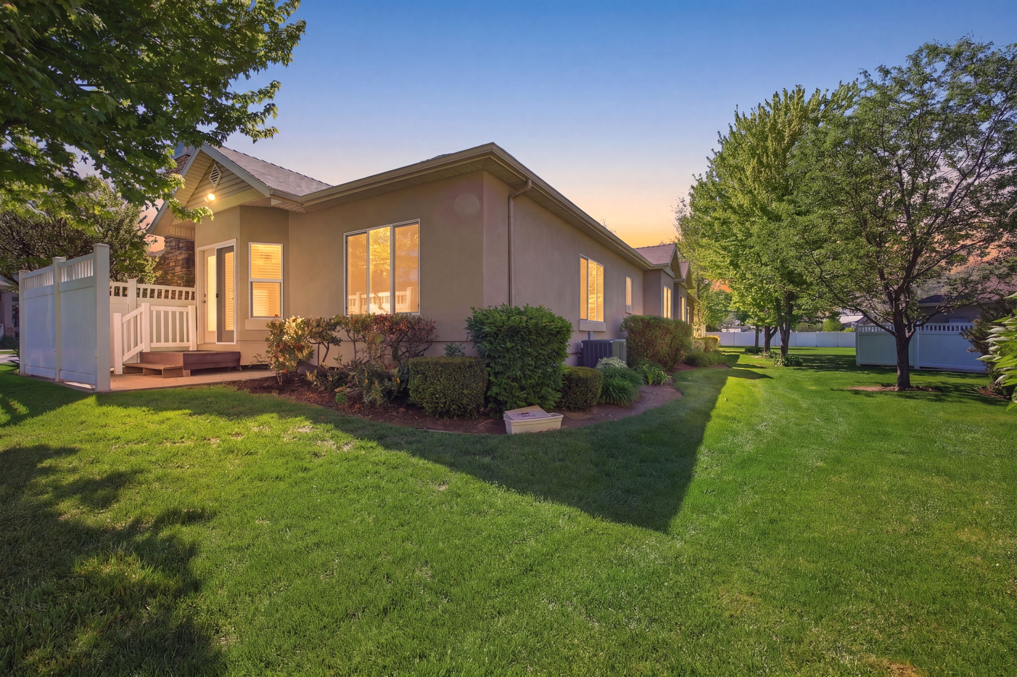 Expansive lawn area featuring mature trees and a privacy fence