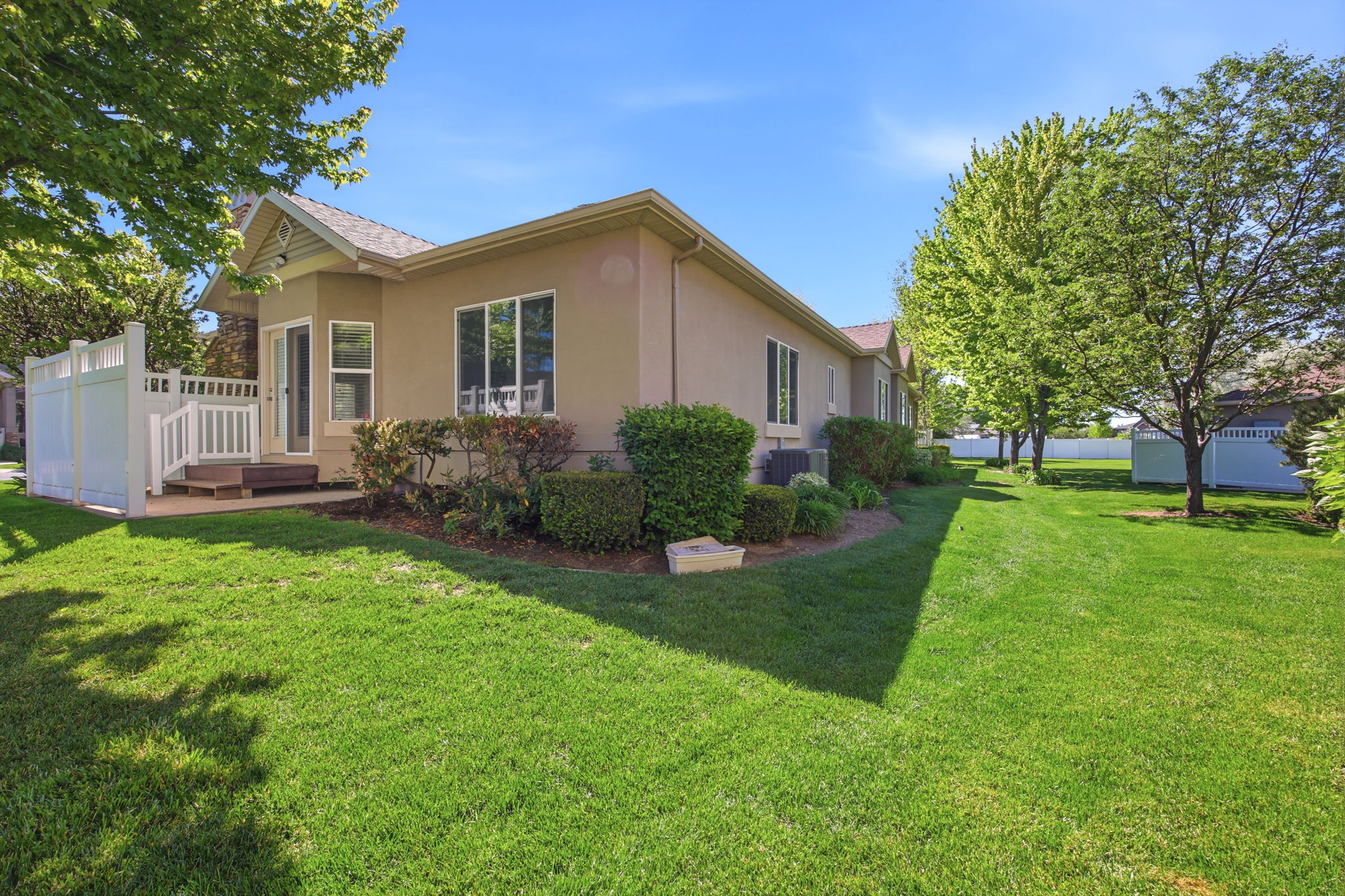 Expansive grassy yard area with mature trees and shrubbery