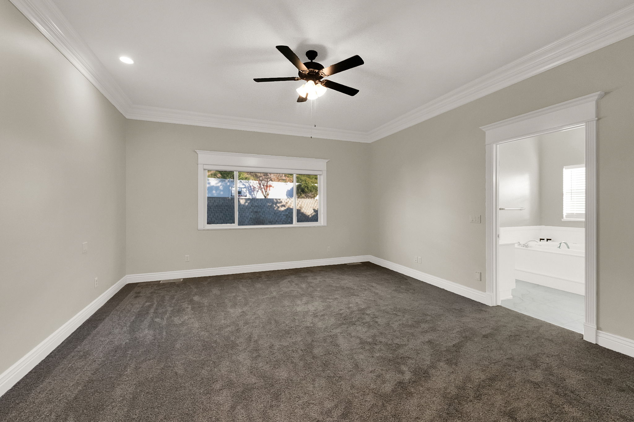 Spacious room featuring gray carpet flooring, a ceiling fan with light fixture, recessed lighting, and white crown molding