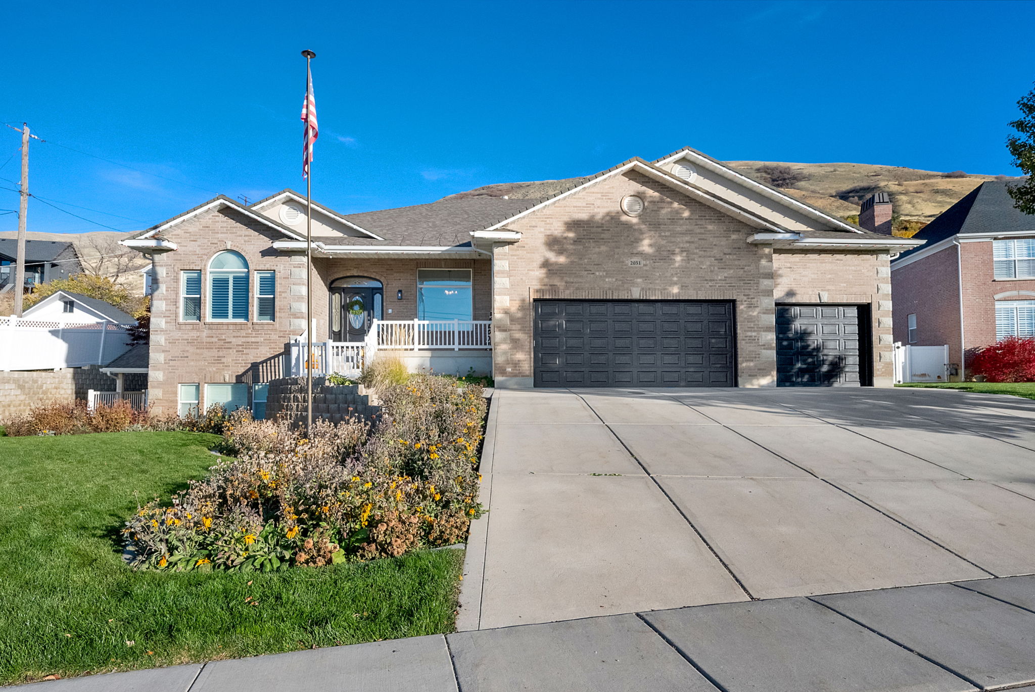 Brick and stone facade residence featuring a two-car garage and an additional single-car garage