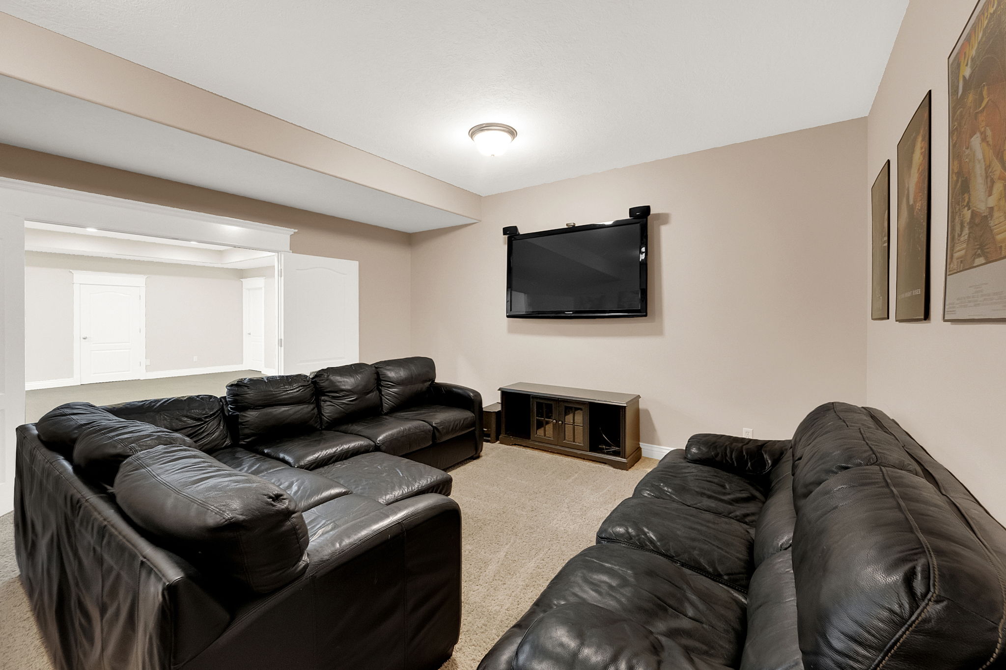 Spacious room with neutral wall tones and recessed lighting