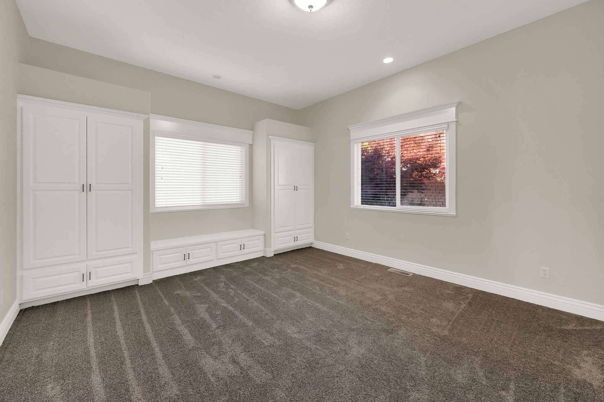 Neutral-toned room featuring a window with white blinds, recessed lighting, and a flush mount ceiling fixture