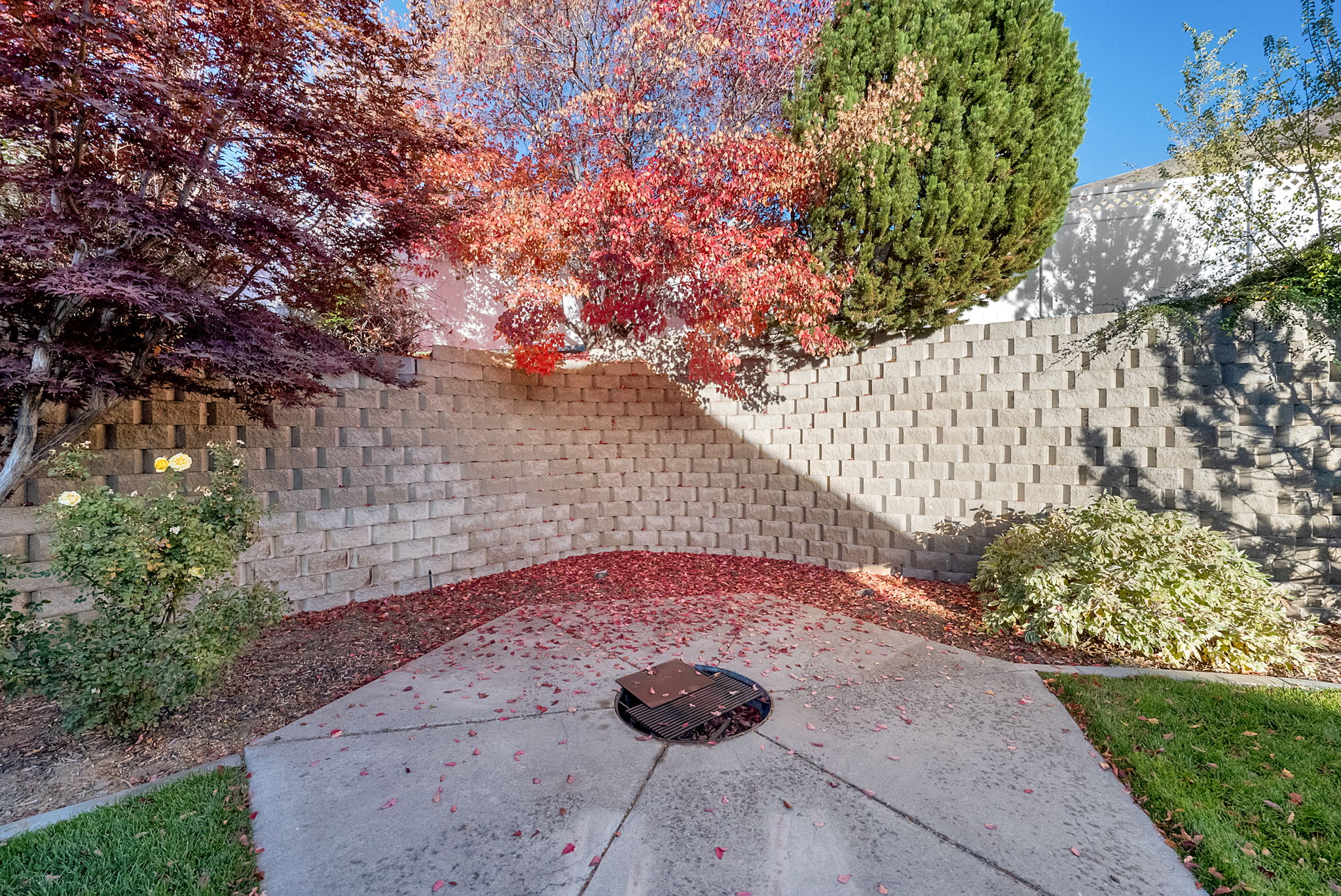 Concrete patio area with a perimeter retaining wall featuring modular block construction