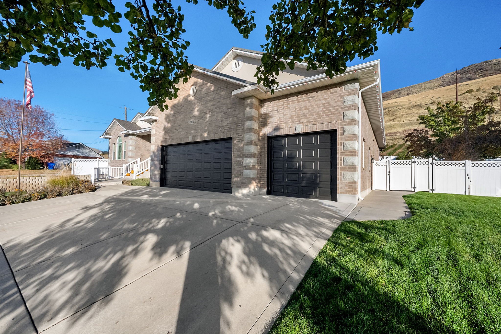 Brick and stone exterior featuring two black paneled garage doors