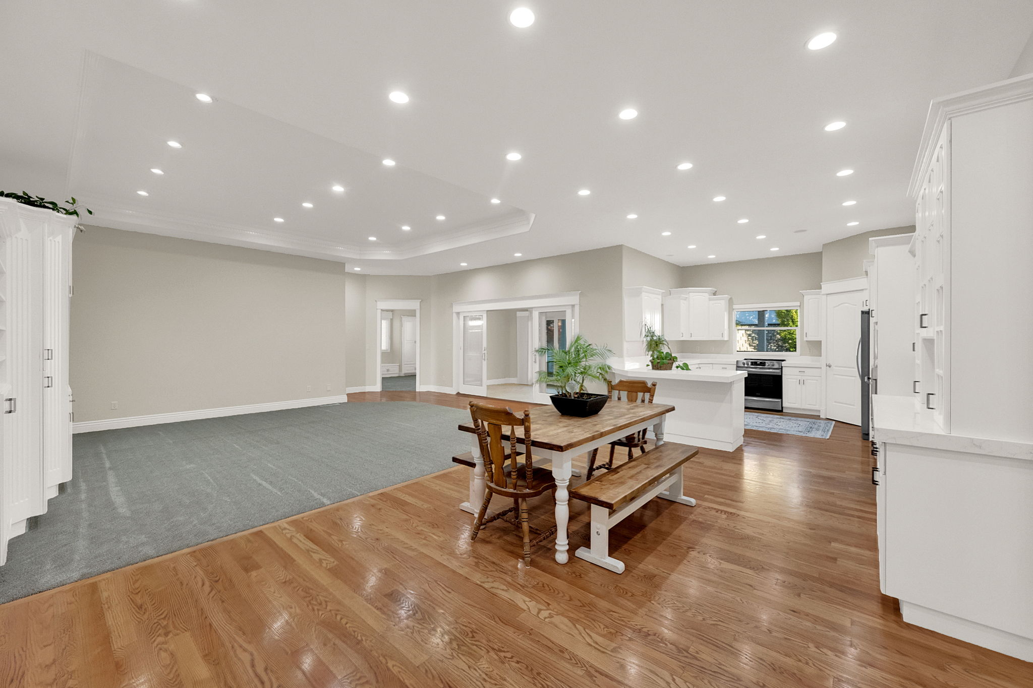 Expansive open-concept living area featuring wood-finish flooring, recessed lighting, and crown molding