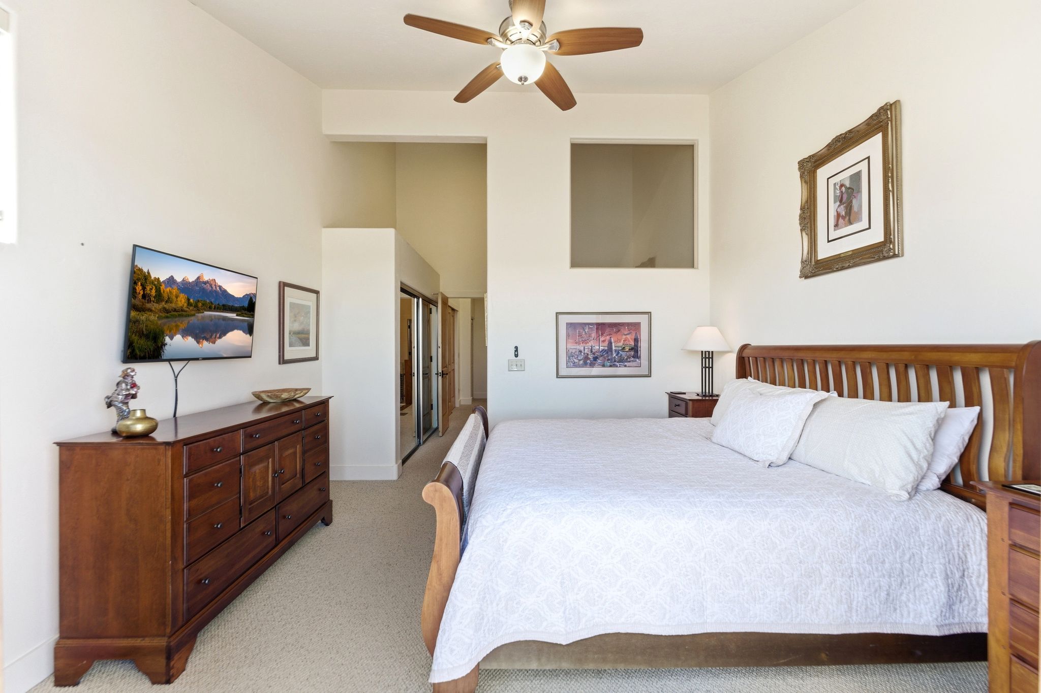 Room featuring vaulted ceilings with a ceiling fan, a built-in window opening, and a sliding mirrored closet door