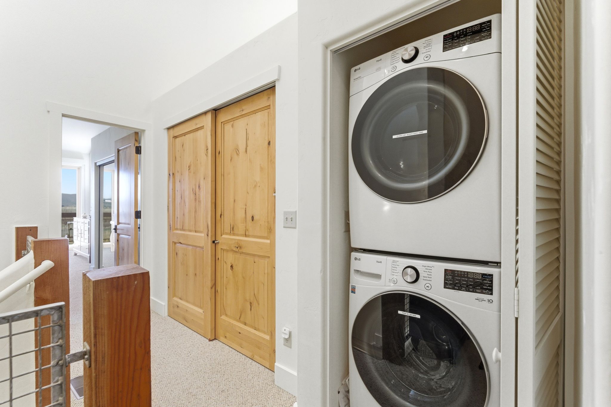 Integrated laundry closet featuring stacked washer and dryer units