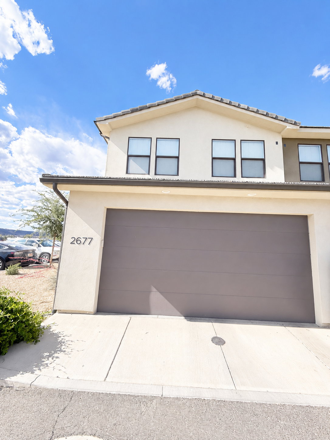 Contemporary stucco exterior with a brown garage door