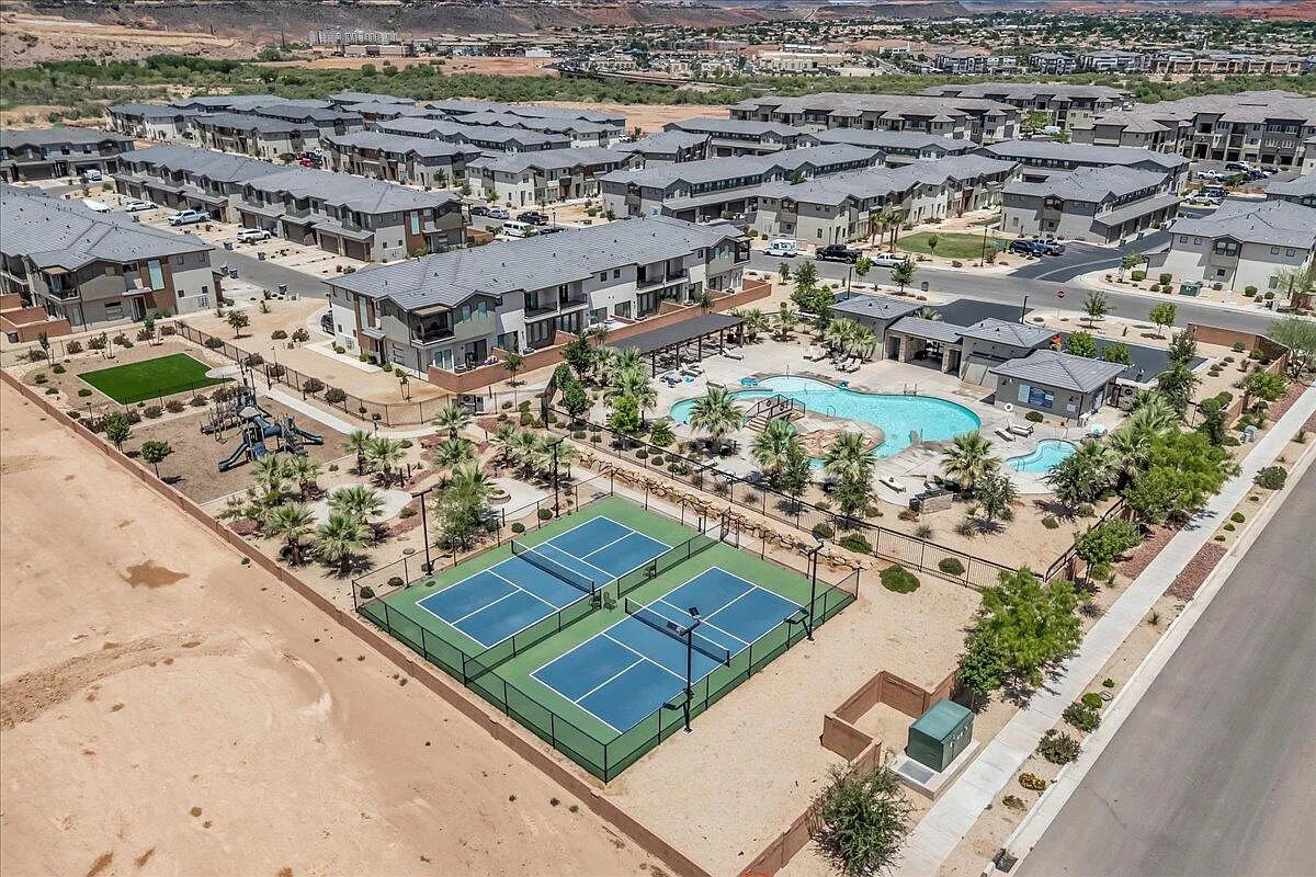 Community amenities featuring a multi-tiered swimming pool, two pickleball courts, and a playground with a turf area