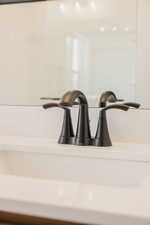 Matte black faucet with dual lever handles, set against a pristine white countertop and an integrated sink