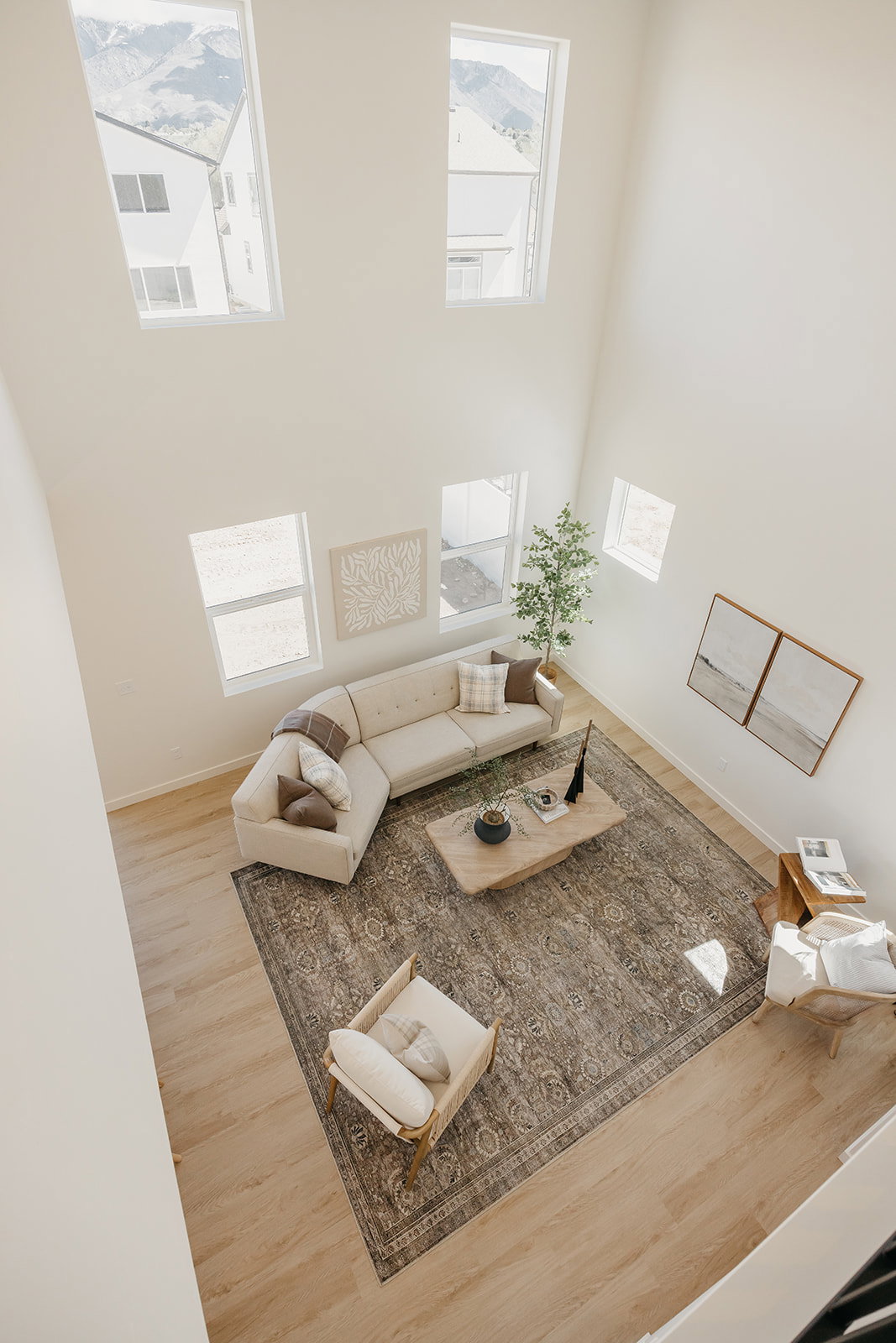 Two-story living area featuring tall ceilings, wood-finish flooring, and multiple windows