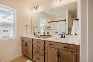 Double vanity with undermount sinks, light-toned wood cabinetry, and a quartz countertop