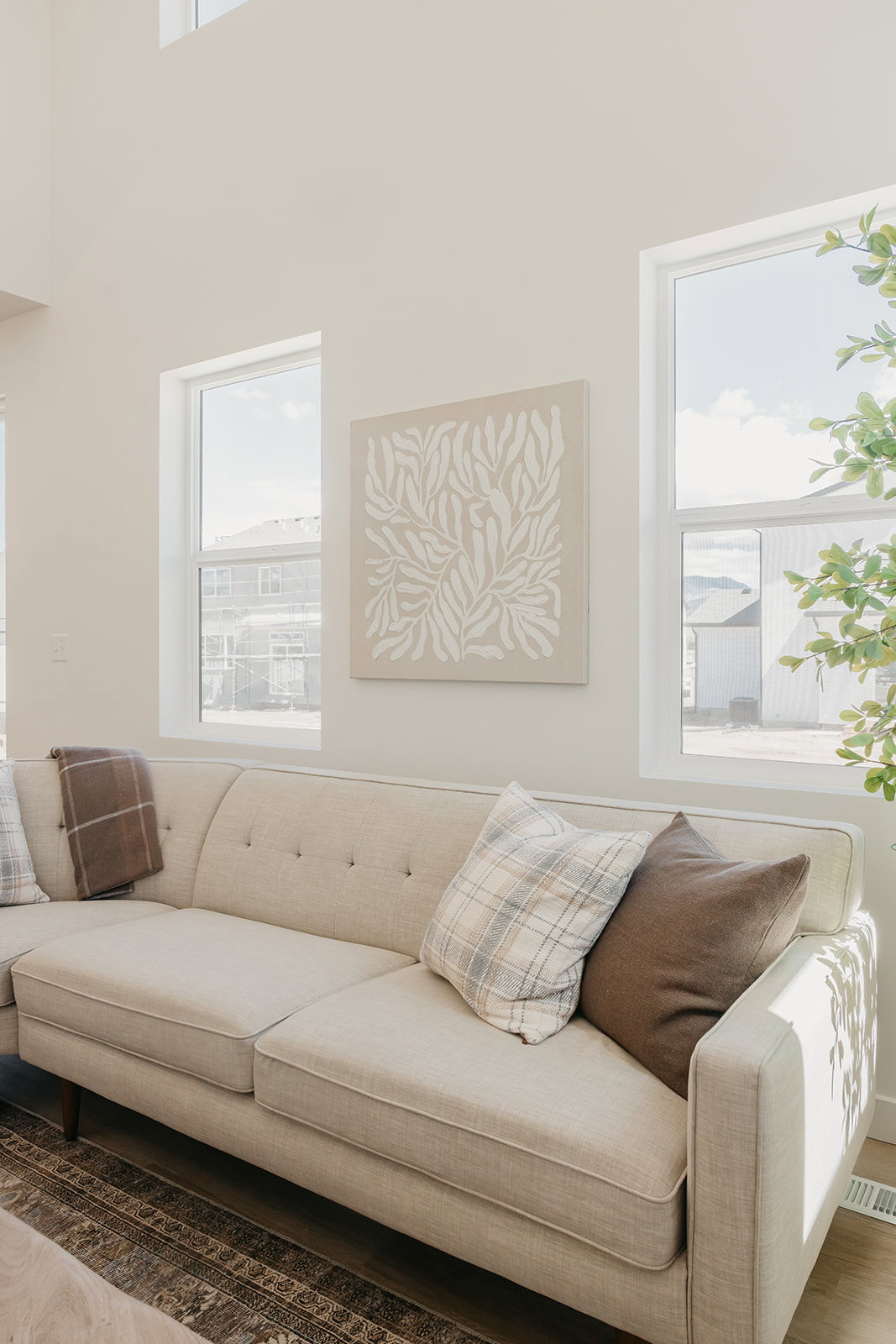 Living area featuring high ceilings, multiple large windows, and light wood-finish flooring