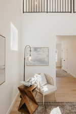Two-story entryway featuring wood-finish flooring, a contemporary black metal railing, and white walls
