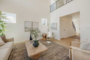 Soaring ceiling in the living area featuring light wood-finish flooring
