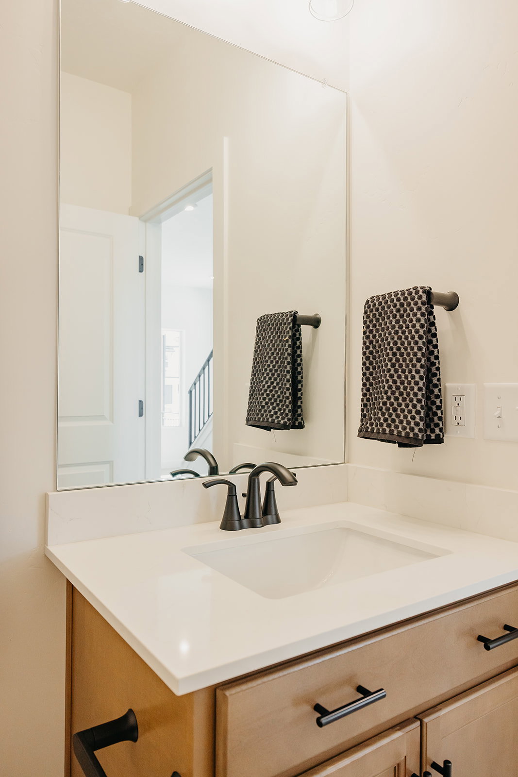 Bathroom vanity with an integrated sink, light-toned countertop, and matte black faucet
