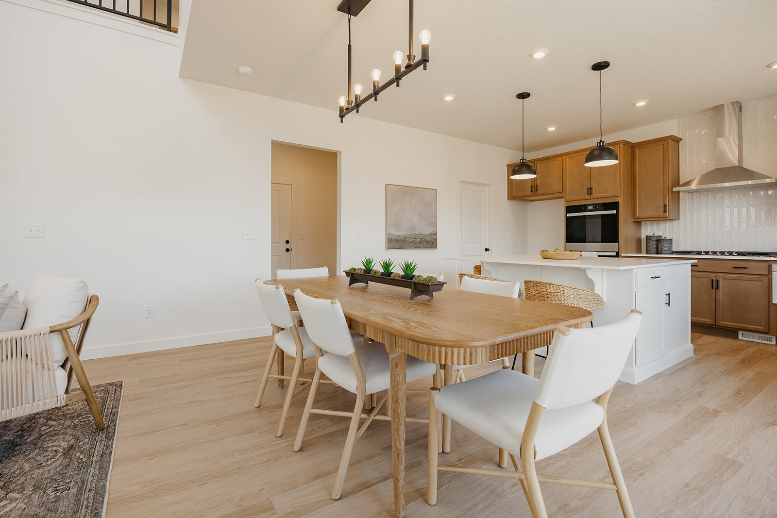 Open-concept dining area featuring wood-finish flooring, a contemporary linear chandelier, and recessed lighting