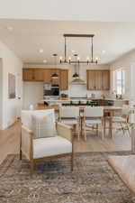 Open-concept living area featuring wood-finish flooring, recessed lighting, and a modern chandelier