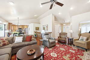 Vaulted ceilings enhance this living area featuring wood-finish flooring and recessed lighting