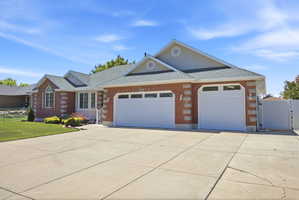 Brick facade residence featuring a multi-car garage with two white doors