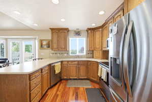 Kitchen featuring wood-finish flooring, light-toned countertops, and wood cabinetry