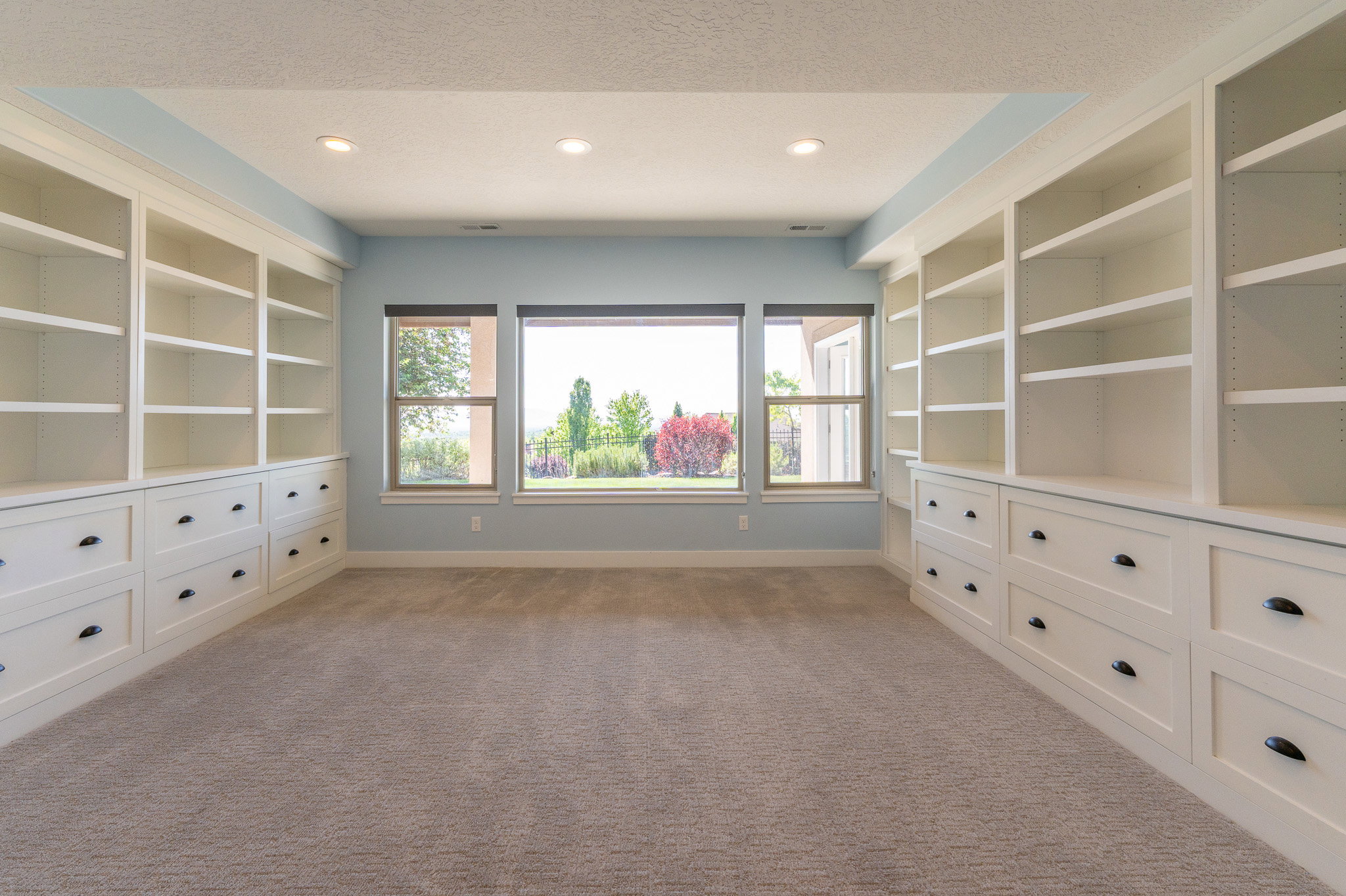 Room featuring extensive built-in cabinetry with integrated shelving and drawer storage