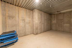 Concrete walls surrounding a poured concrete floor and a corrugated metal ceiling