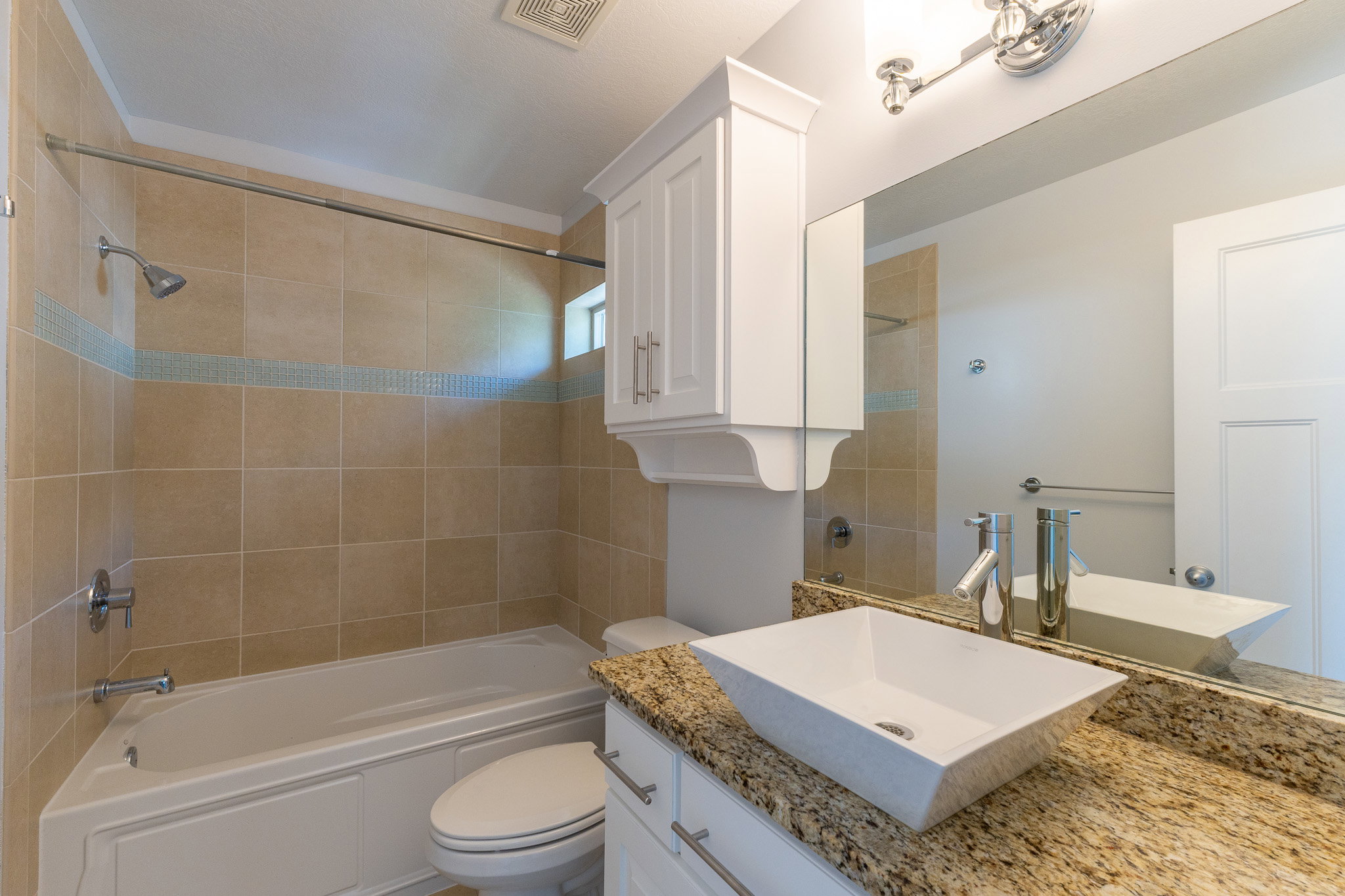 Bathroom featuring a soaking tub with subway tile surround and decorative accent band
