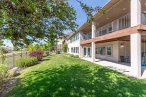 Expansive backyard featuring a lush lawn, mature trees, and decorative shrubbery