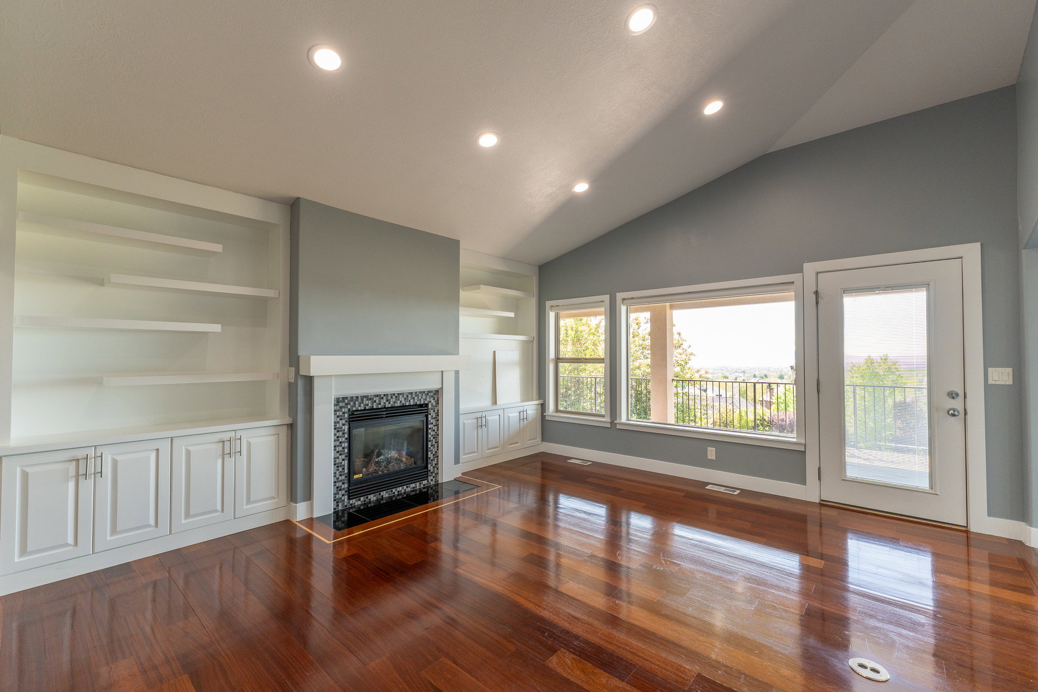 Living area featuring a vaulted ceiling with recessed lighting