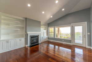Living area featuring a vaulted ceiling with recessed lighting