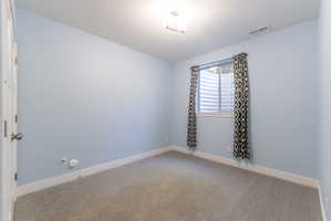 Light blue painted walls and grey carpeting define this room