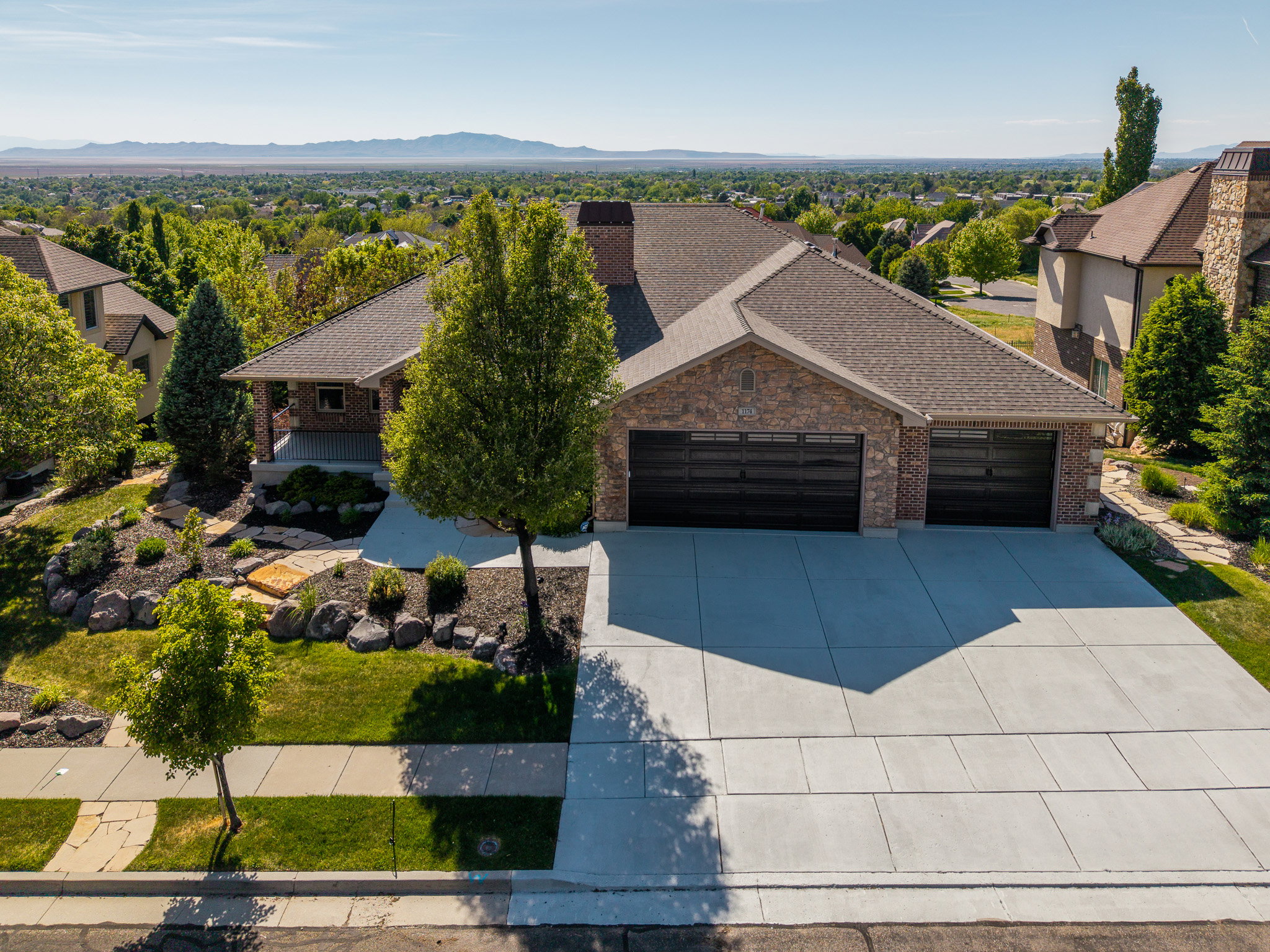 Brick and stone exterior featuring a covered porch entrance and a multi-car driveway