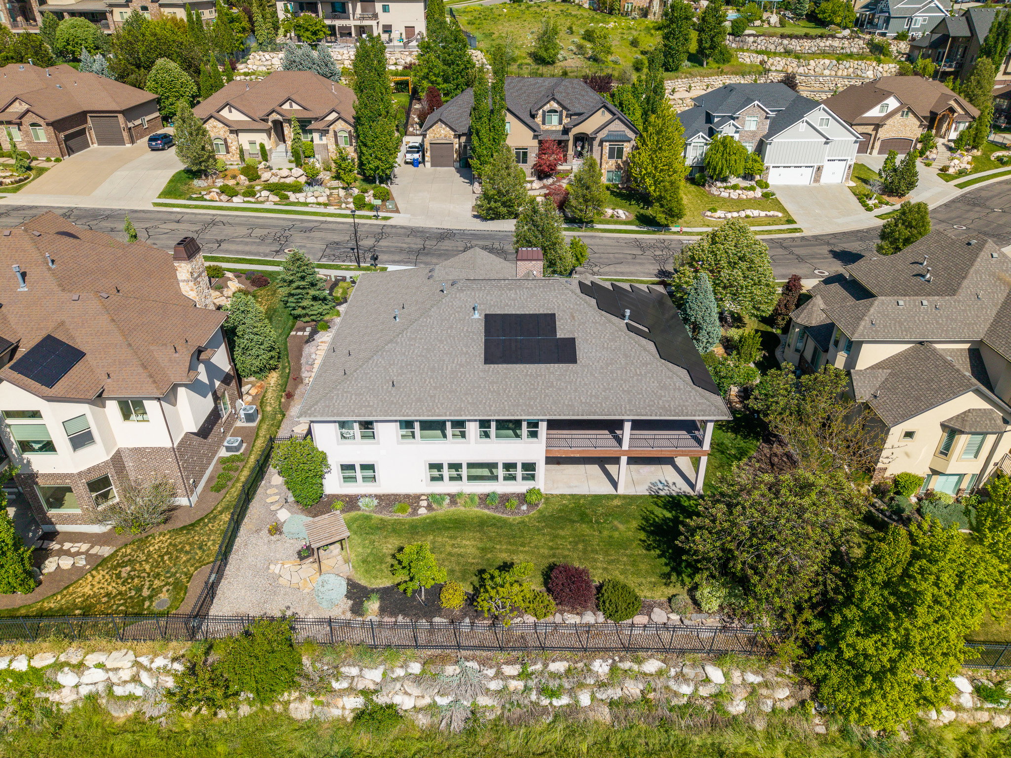 Contemporary residence featuring a spacious rear deck, ground-level patio, and a verdant lawn