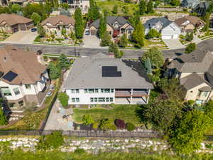 Contemporary residence featuring a spacious rear deck, ground-level patio, and a verdant lawn