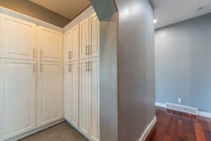 Built-in white cabinetry with brushed nickel hardware, tile flooring, and recessed lighting