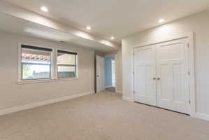 Spacious room featuring neutral carpeting and recessed lighting