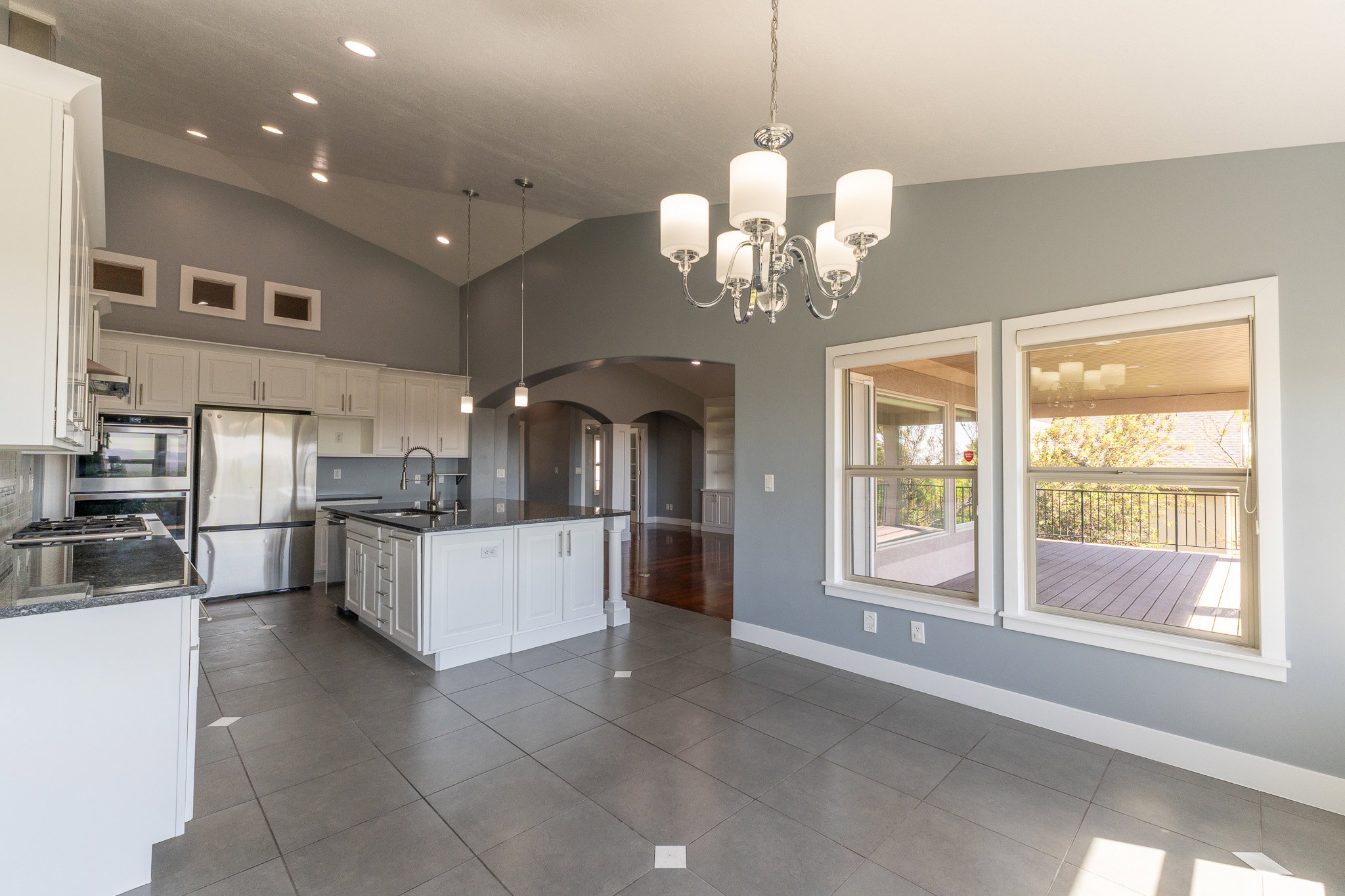 Expansive kitchen and dining area featuring vaulted ceilings, recessed lighting, and a chandelier