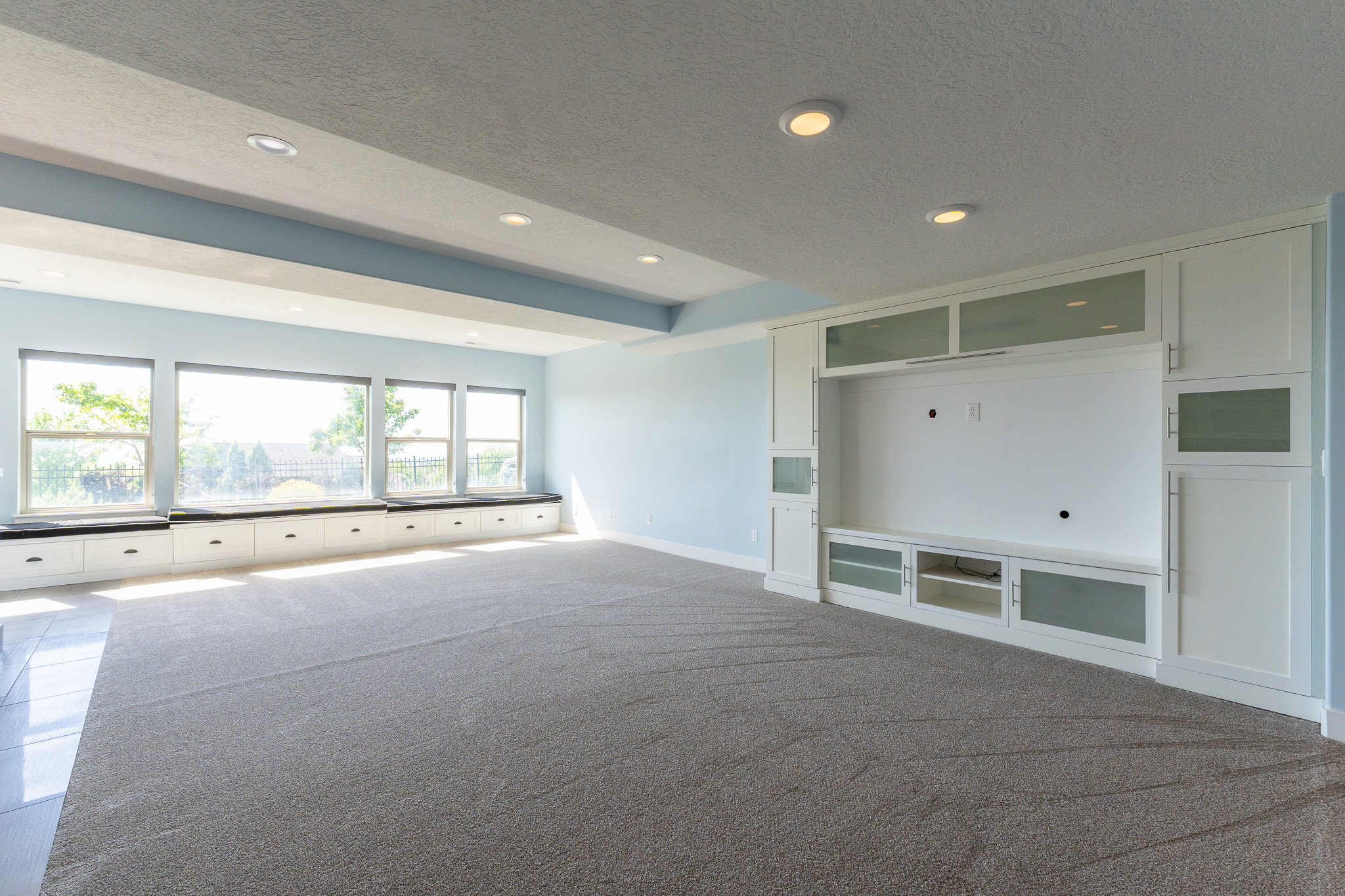Spacious room featuring a wall of windows with built-in bench seating and integrated storage