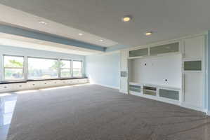 Spacious room featuring a wall of windows with built-in bench seating and integrated storage