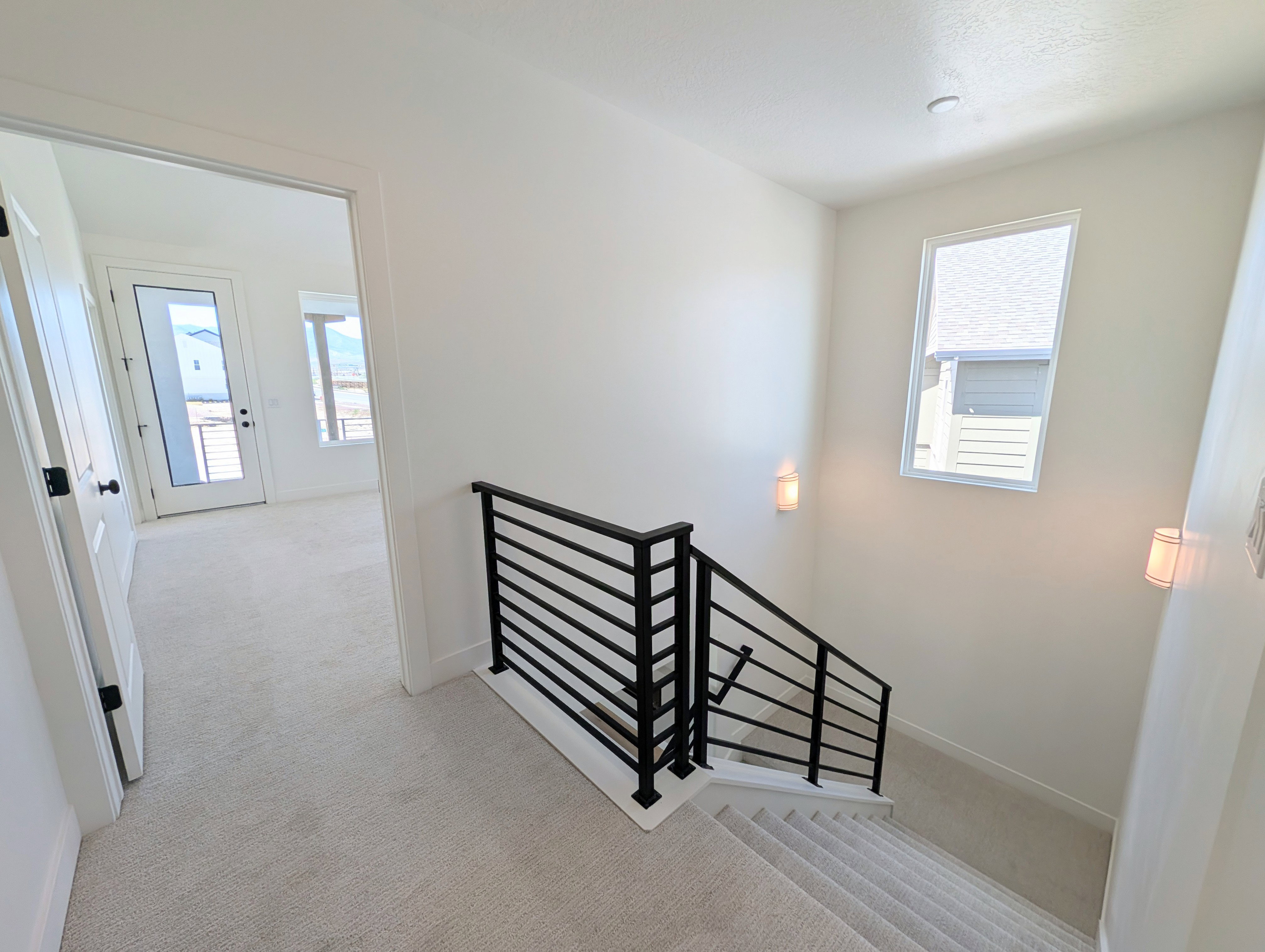 Upper-level hallway featuring light-toned carpeting and white walls