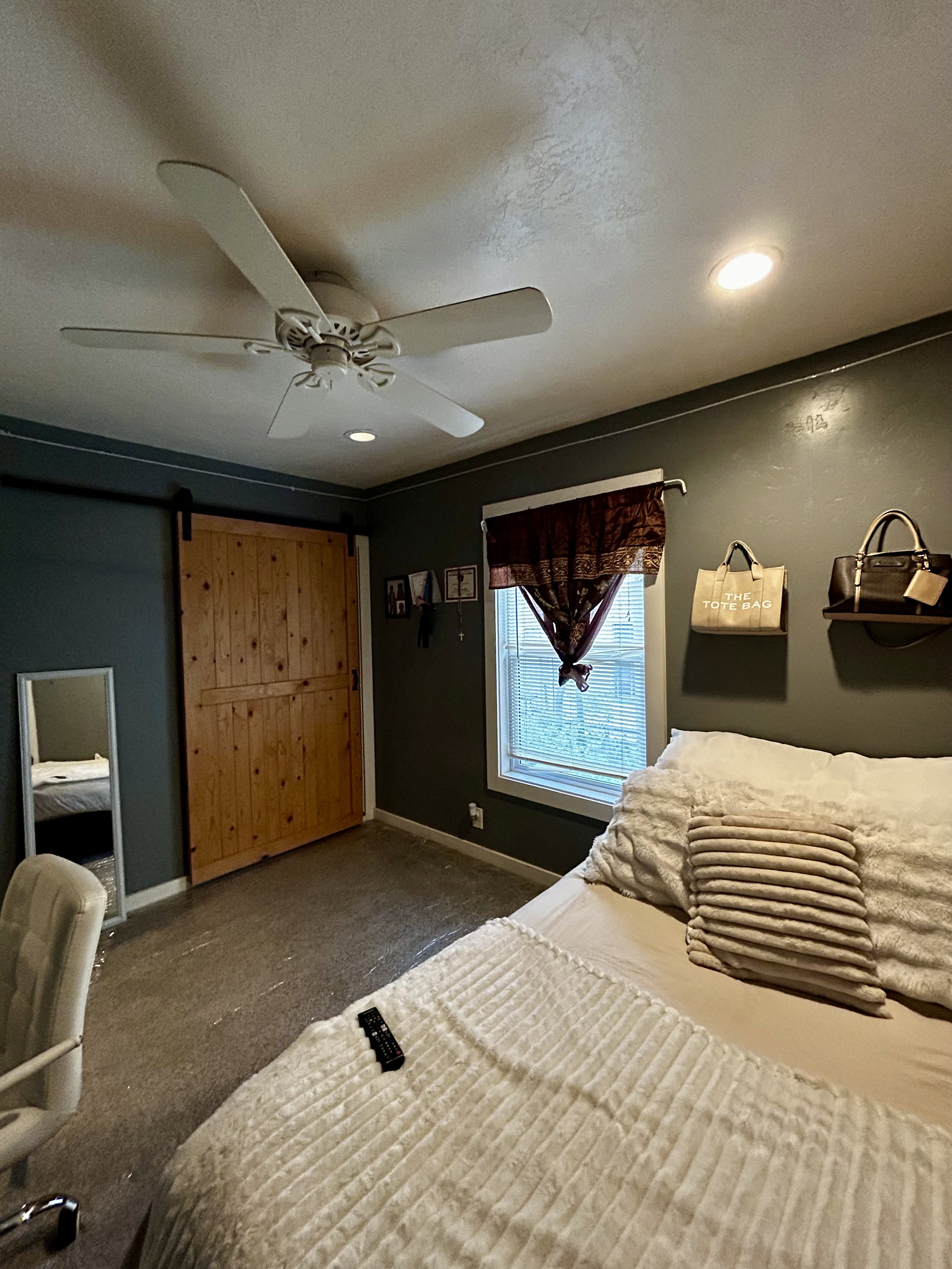 Bedroom #2 Spacious room featuring a natural wood barn door, window with white trim, and a ceiling fan