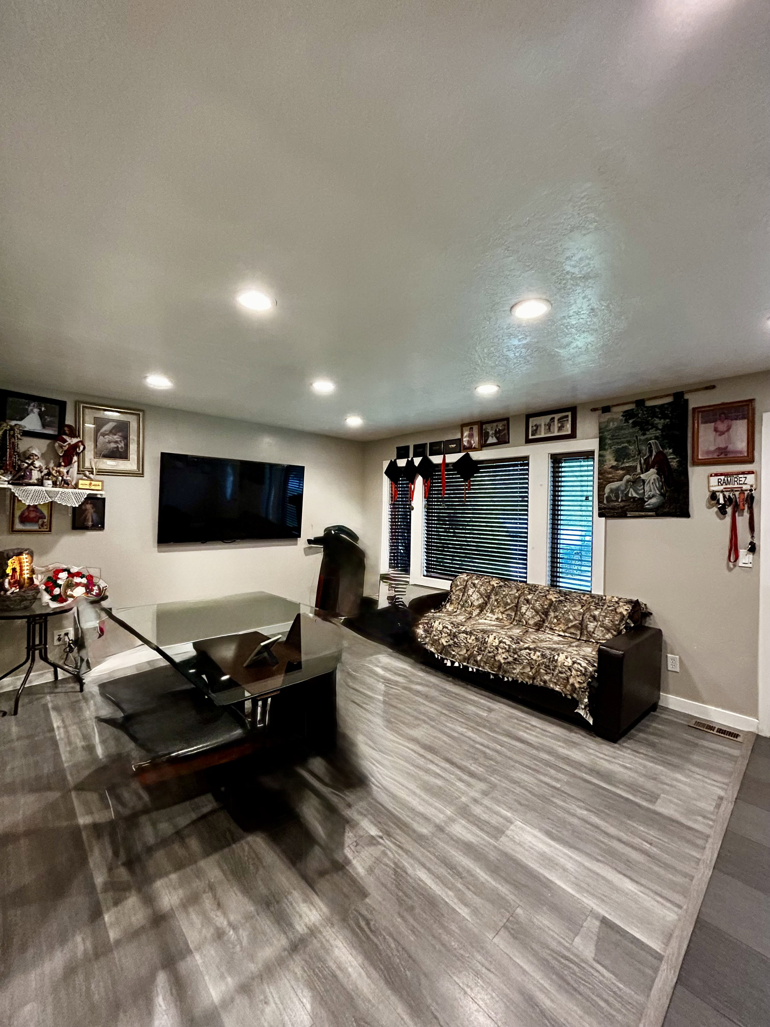 Spacious living area, recessed lighting, and large windows with blinds
